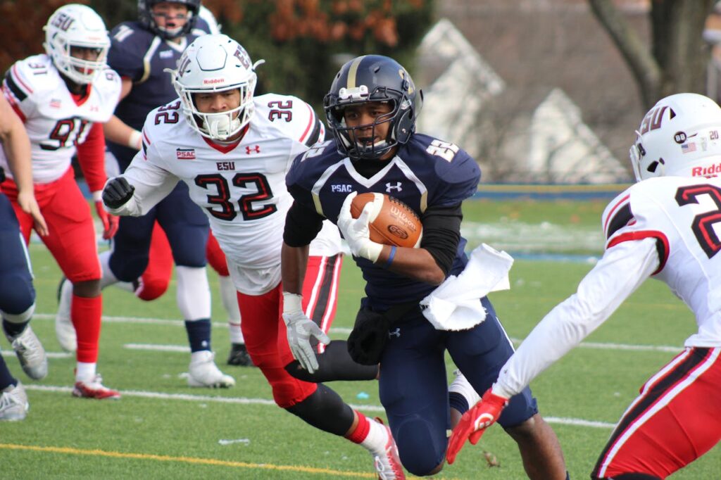 Dynamic college football match with players in action, showcasing athleticism and teamwork on the field.